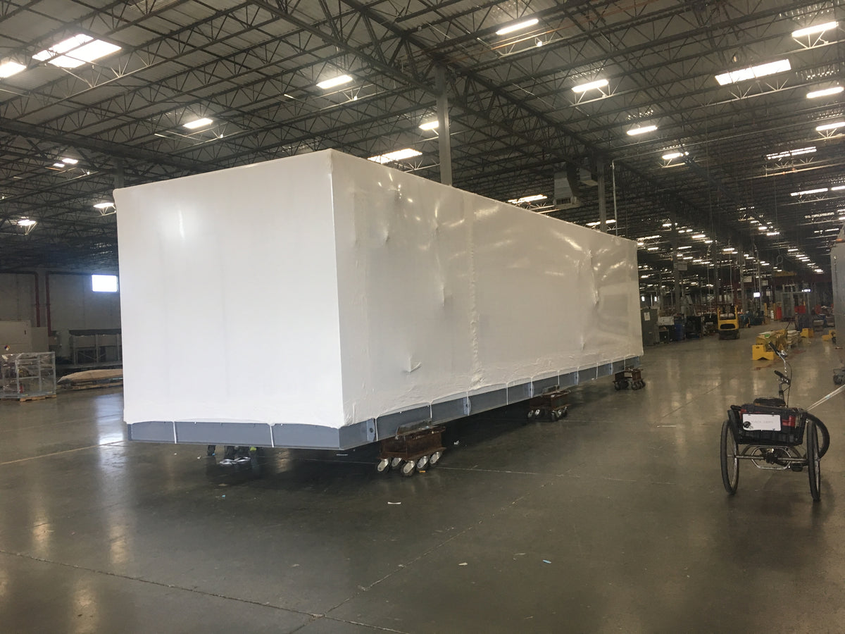 Large shrink-wrapped industrial load inside a manufacturing facility